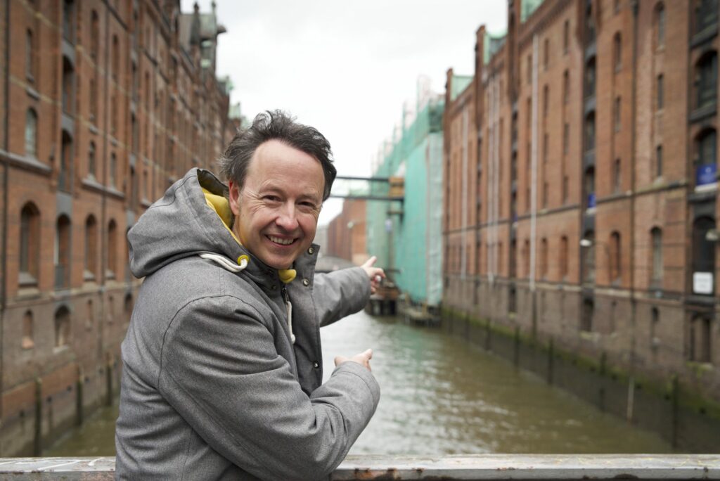 Frederik Braun zeigt auf die Wunderland-Brücke über das Fleet